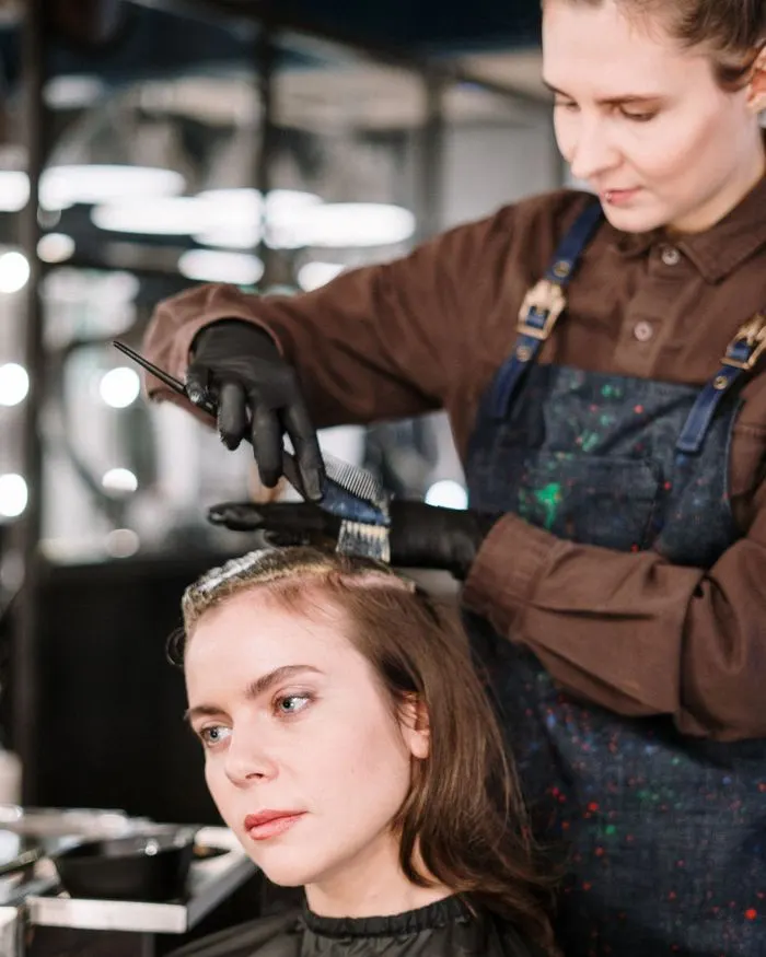 A hairstylist colouring a client's hair